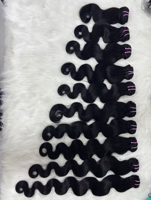 100% raw Vietnamese body wave hair bundles in natural black arranged by length on a white fur background, Grade 12A
